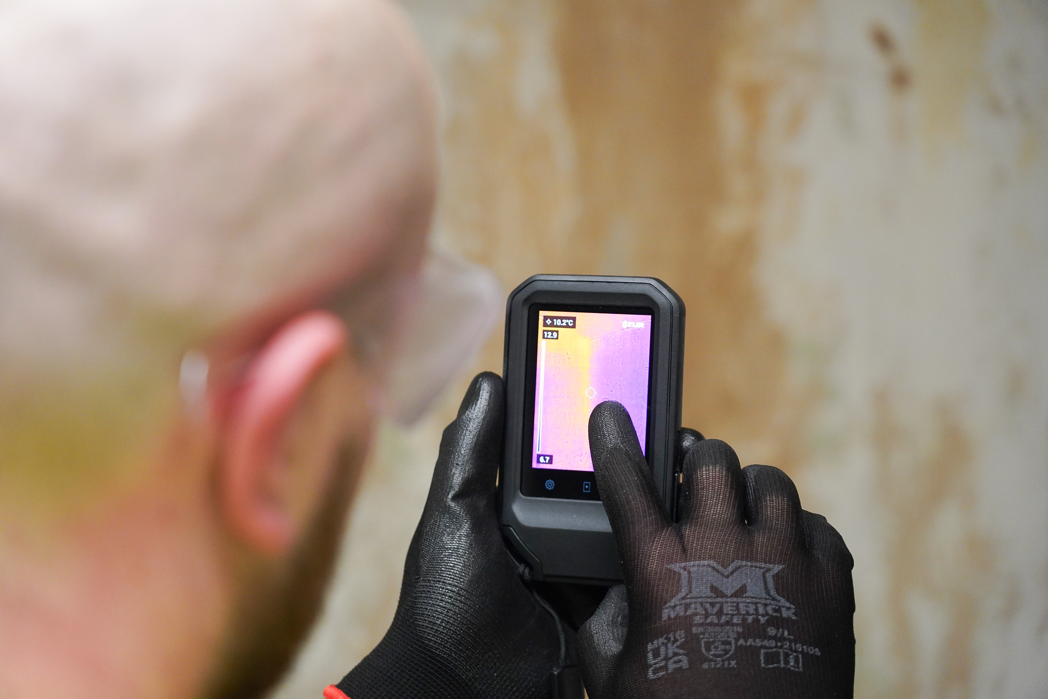 Operative measuring moister in an exposed wall wearing protective gloves
