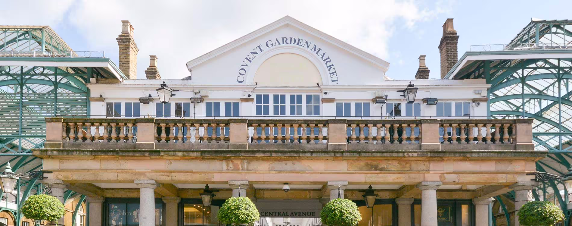 The beautifully restored classical facade of Covent Garden Market, a Grade II* listed building, showcasing its grand stone entrance and iconic signage.