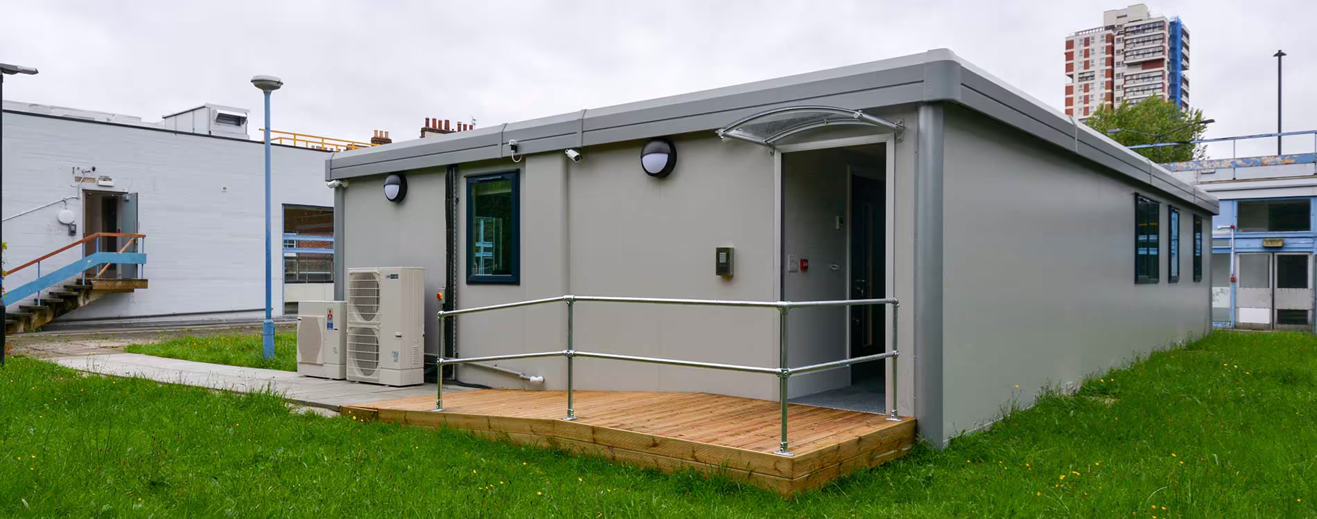 Wide shot of modular building sections being lifted by a crane during installation at a construction site, showcasing offsite construction efficiency.