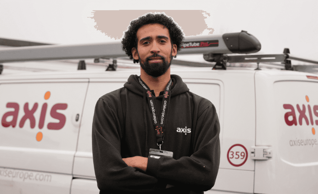 Man with black hoodie, standing in front of a white Axis Europe van.