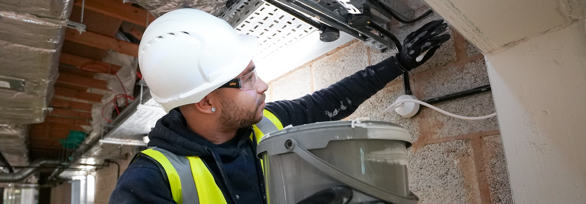 operative completing passive fire works in high vis jacket with a white safety hat