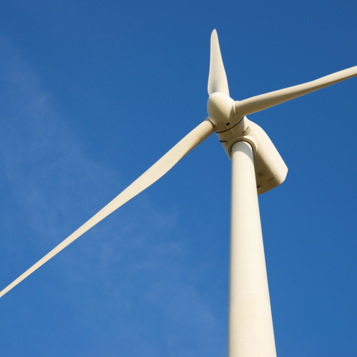 White wind turbine with blue sky