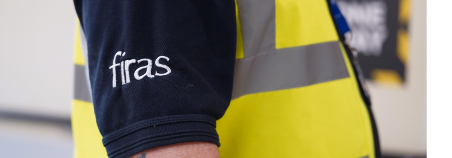 Close up shot of FIRAS log on navy blue shirt with yellow High Viz vest