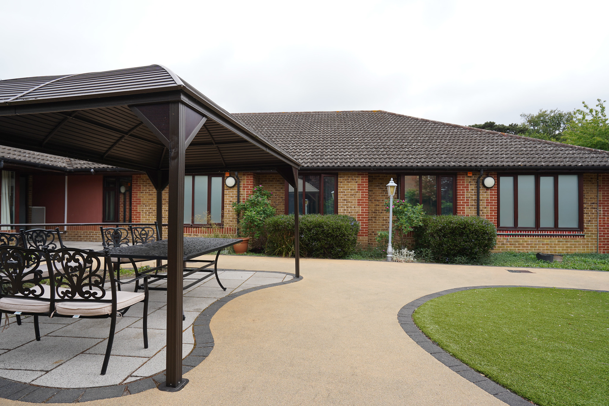 outside communal garden outside care unit in hertfordshire showing the exterior of the main building and gazebo area