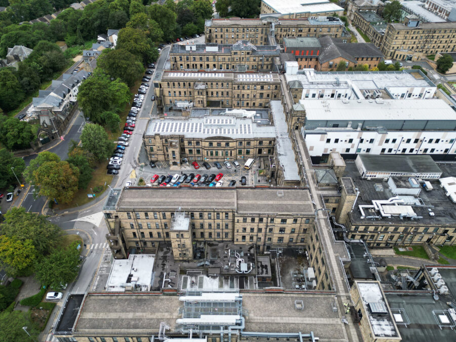 overhead shot of hospital showing multiple old buildings and a line of trees to the left