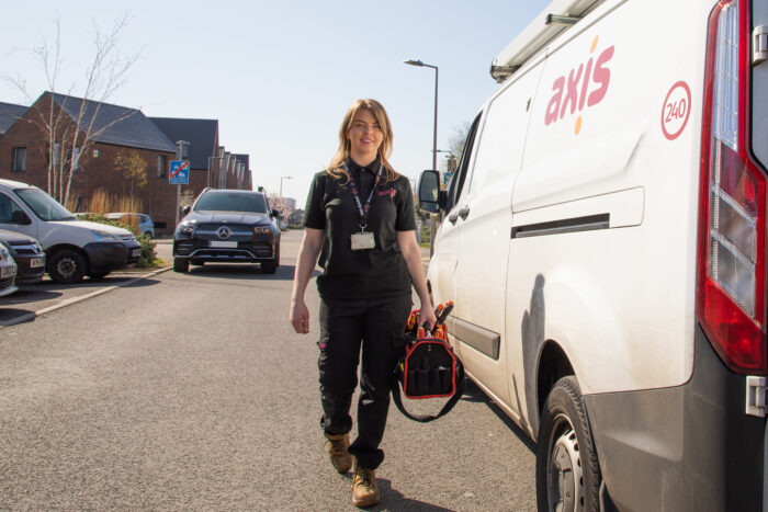 operative outside van holding tool bag wearing black uniform