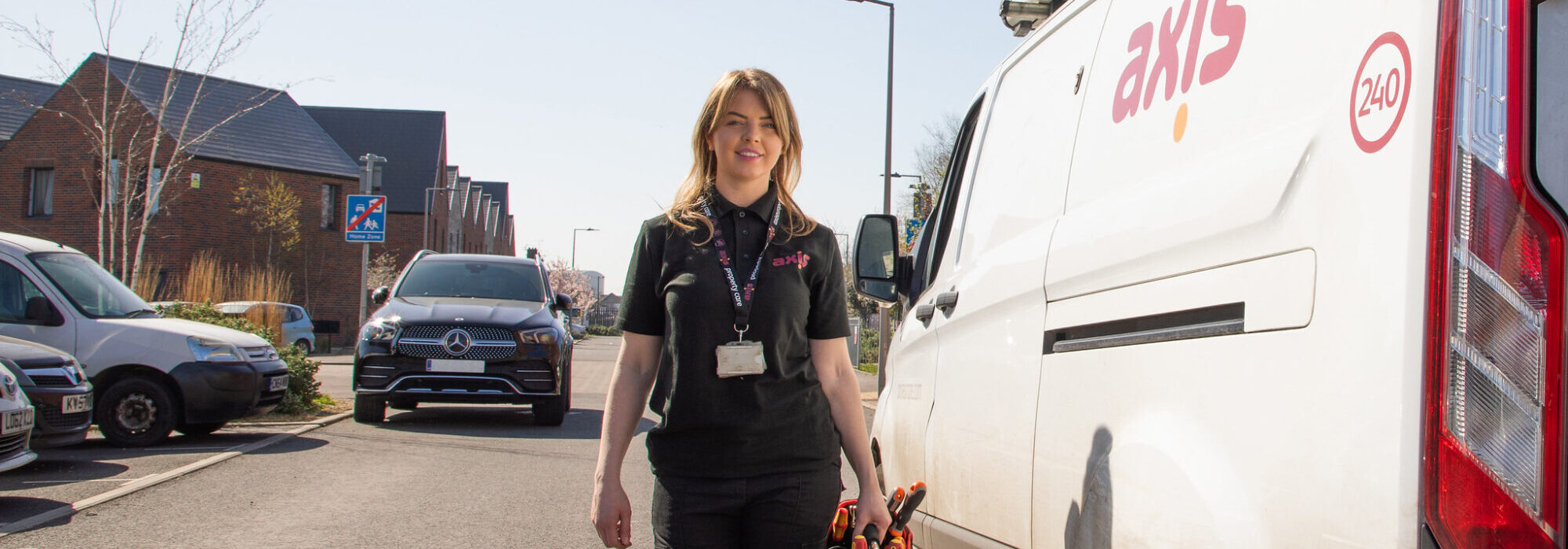 operative outside van holding tool bag wearing black uniform